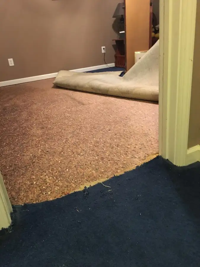 Carpet pad removal revealing water damage during Water Mitigation Services in Whispering Pines